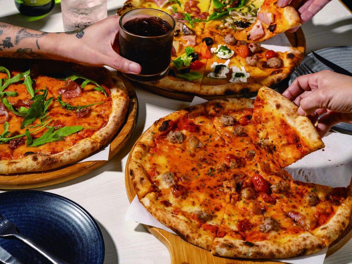 Hand-stretched pizzas shared across a table